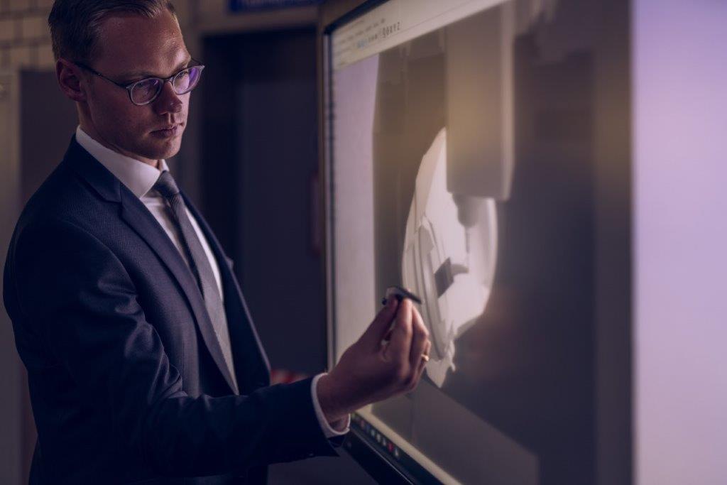 Marcel Wichmann holding a real hip implant in front of its digital twin